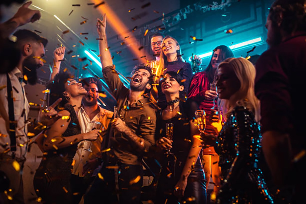 Group of energetic young people dancing at a party in a nightclub